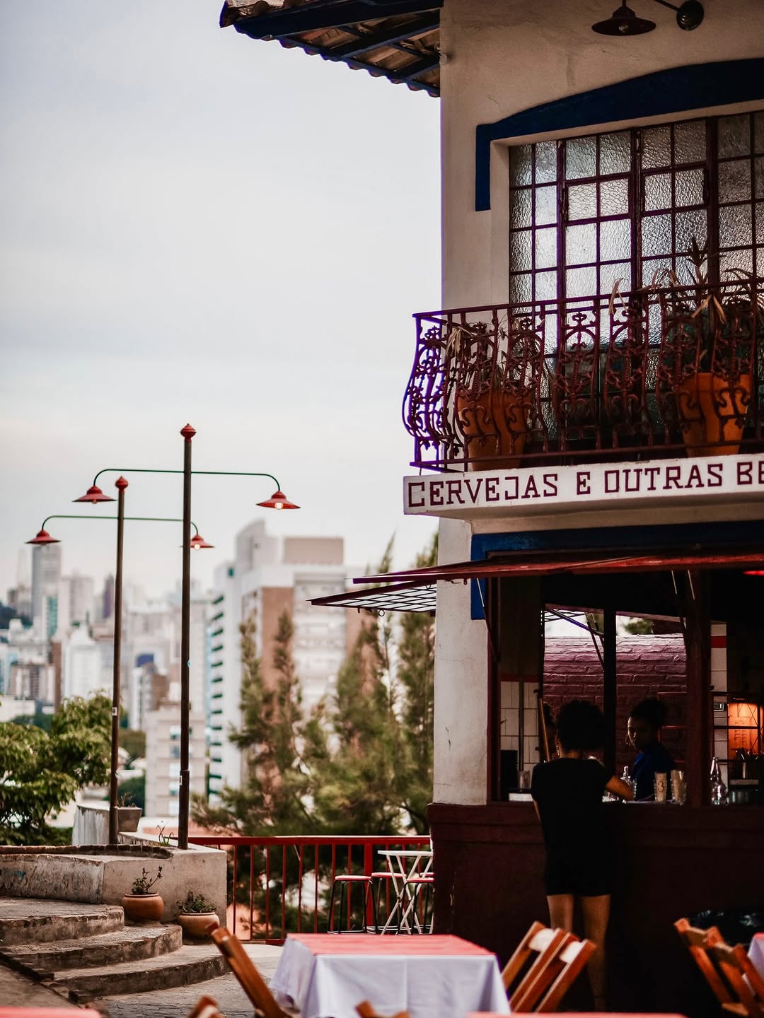 Casa de esquina do Forno da Saudade vista da praça, com mesas na calçada